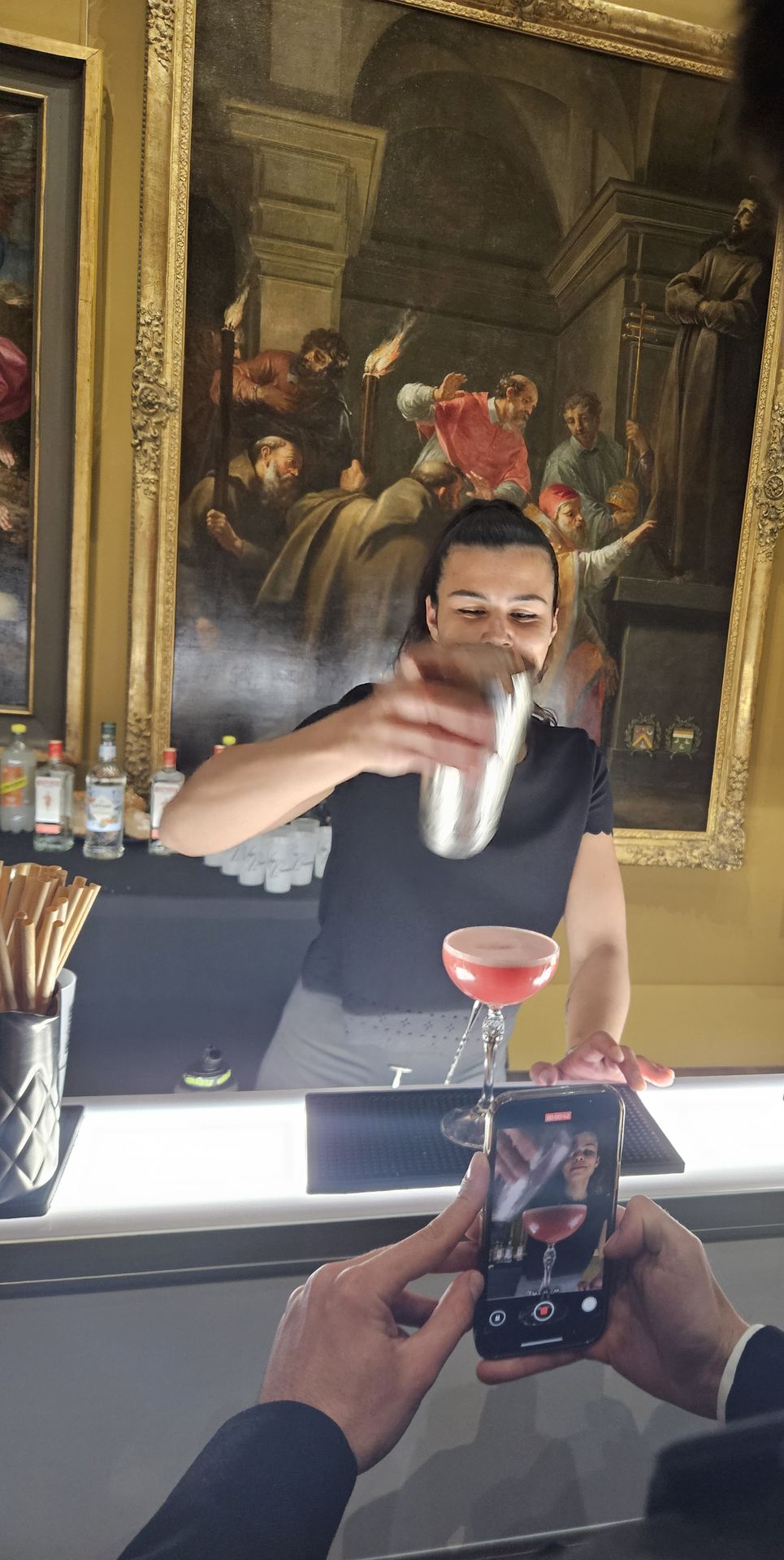 Barmaid au shaker derrière un bar éphémère installé dans un musée