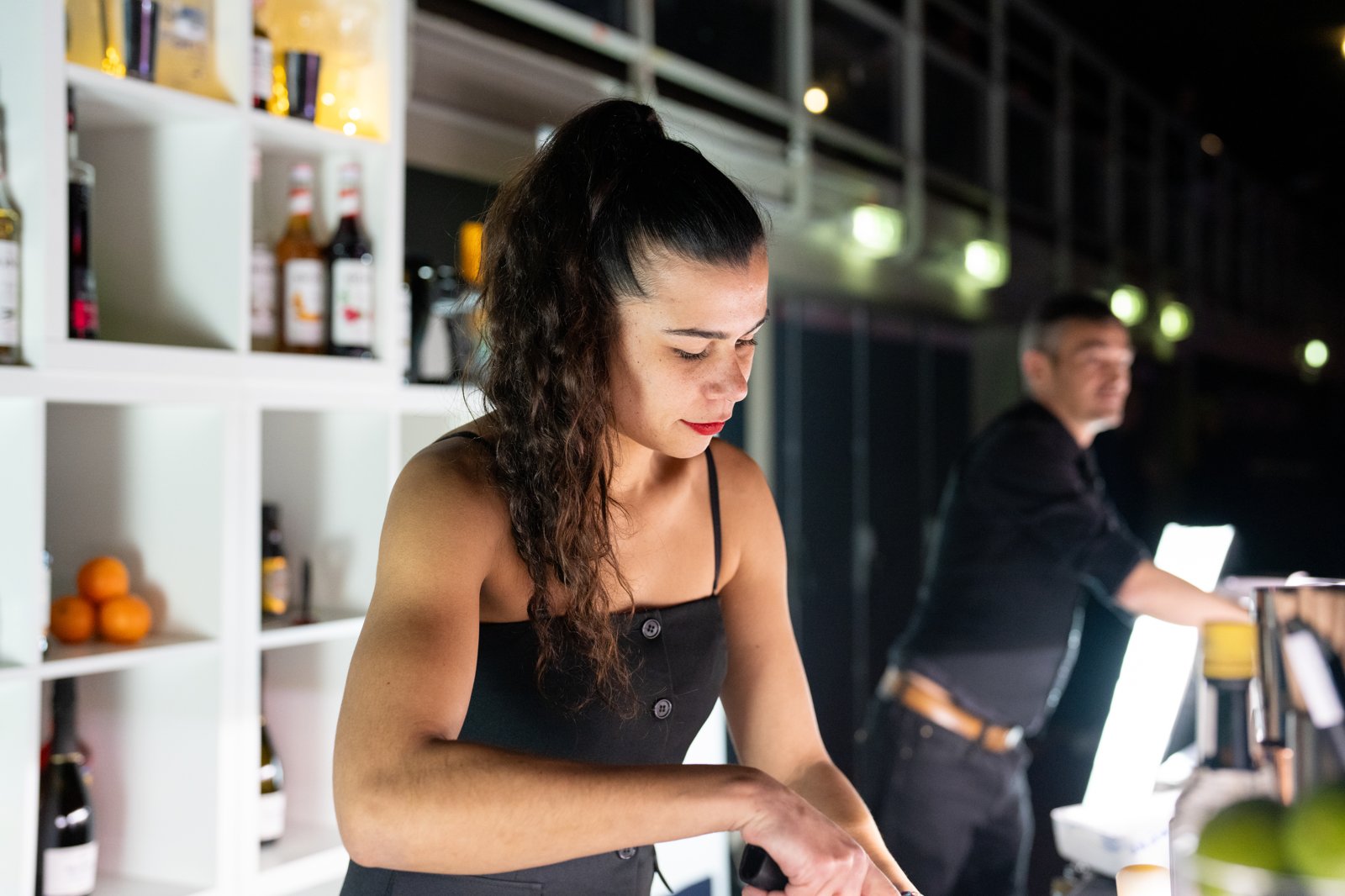 Barmaid professionnelle au service derrière un bar à cocktails