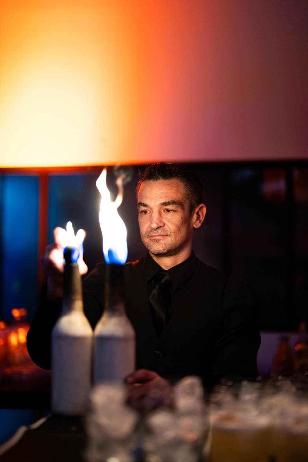 Barman réalisant un flair avec une bouteille enflammée
